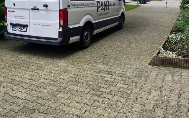 Geparkter Transporter von P&N Kanaltechnik zwischen Wohnblöcken